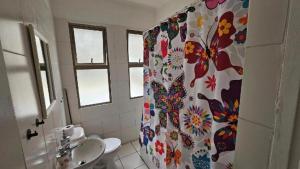 a bathroom with a shower curtain with flowers on it at Hostal Quintamar Viña del mar in Viña del Mar +96 photos