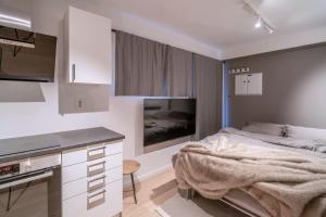 ein weißes Schlafzimmer mit Bett und Küche in der Unterkunft Staying Apt 6 in Tromsø