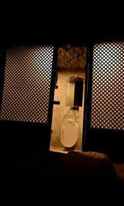 a bathroom with a toilet in a room with two windows at Ninive Homestay in Nu Chid