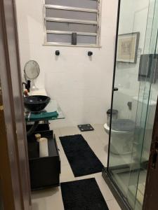 a bathroom with a glass shower and a toilet at Quarto vista mar in Rio de Janeiro
