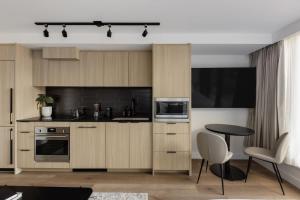 a kitchen with wooden cabinets and a table and a television at Keefer House in Vancouver