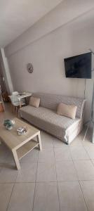 a living room with a couch and a table at Haras'house in Nei Poroi +1 photo