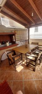 a dining room with a wooden table and chairs at Haras'house in Nei Poroi