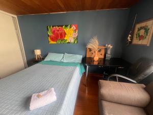 ボゴタにあるHabitaciones junto a Universidad del Bosqueのベッドと椅子と机のある寝室