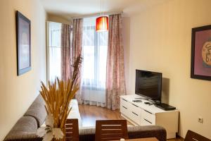a living room with a couch and a television at Cozy and warm apartment with a separate bedroom in Bansko