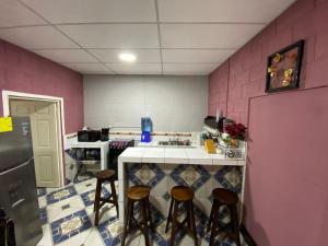 a kitchen with a counter and stools in it at Casa Cahuí in El Remate