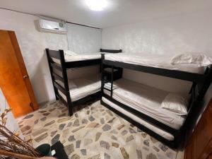 two bunk beds in a room with a carpet at Apartamento cerca a la playa en el rodadero in La Tigrera