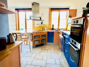 cocina con armarios azules y suelo de baldosa en Chez Pierre et Fabienne, en Le Locle 9 fotos más