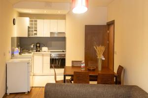 a kitchen and dining room with a table and a refrigerator at Cozy and warm apartment with a separate bedroom in Bansko