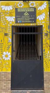 a black door in front of a building with flowers at Margarida AP 4 in Presidente Figueiredo +2 photos