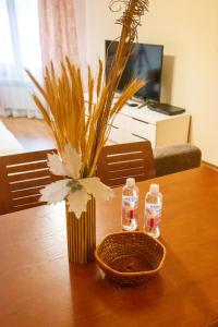 a table with a vase of flowers and two bottles of water at Cozy and warm apartment with a separate bedroom in Bansko