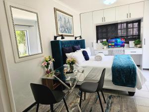 a bedroom with a bed and a table and chairs at The Little Haven in Midrand