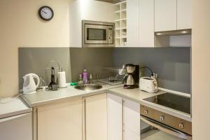 a kitchen with a sink and a microwave at Cozy and warm apartment with a separate bedroom in Bansko