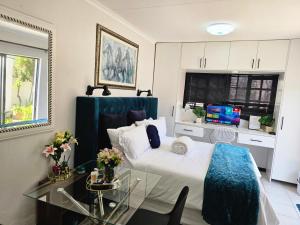 a bedroom with a bed and a glass table at The Little Haven in Midrand