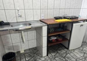 a kitchen with a sink and a small refrigerator at Margarida AP 4 in Presidente Figueiredo