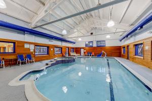 a large indoor pool with blue chairs and tables at Timber Creek #100 in Podunk