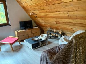 a living room with a wooden ceiling at L Annexe in Mittlach