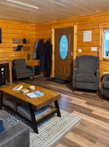 a living room with a table and two chairs and a door at Aurora Ridge Cabin Stunning Views & Aurora Skies in Fairbanks