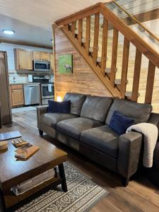 a living room with a couch and a staircase at Aurora Ridge Cabin Stunning Views & Aurora Skies in Fairbanks +59 photos