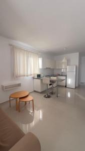 a large white kitchen with a table and a refrigerator at Caesar Resort Alexius in Bahçeler +5 photos