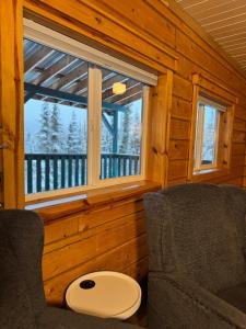 a living room with a chair and a window at Aurora Ridge Cabin Stunning Views & Aurora Skies in Fairbanks