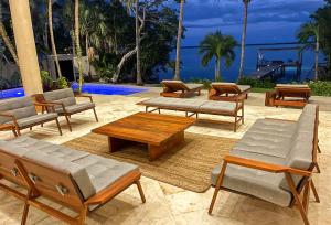 a group of benches and tables on a patio at 7BR Beautiful Waterfront Villa - Perfect Getaway in Calderitas