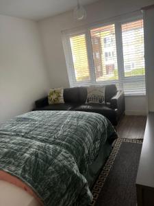 a bedroom with a bed and a couch in it at COSY Rooms in Grove Park