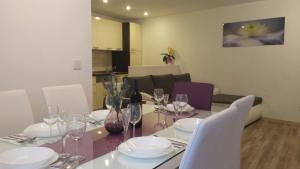 a dining room table with white chairs and a table with wine glasses at Apartment Soric in Senj +12 photos