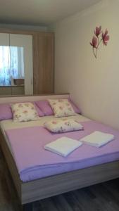 a large bed with purple sheets and pillows on it at Apartment Soric in Senj