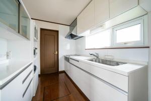 a white kitchen with a sink and a window at SEKKA - Vacation STAY 20179 in Shimo-furano +86 photos