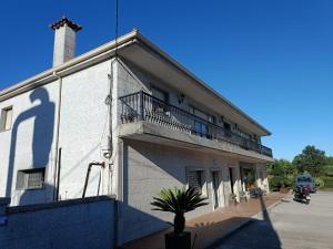 a white building with a balcony and a person on it at casa de los tréboles in Camos