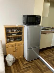 La cuisine est équipée d'un four micro-ondes et d'un réfrigérateur. dans l'établissement Kofu Kitaguchi Plaza Building 908 - Vacation STAY 39123v, à Tachibanachō