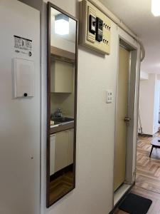 un miroir accroché au mur dans une cuisine dans l'établissement Kofu Kitaguchi Plaza Building 908 - Vacation STAY 39123v, à Tachibanachō 3 autres photos