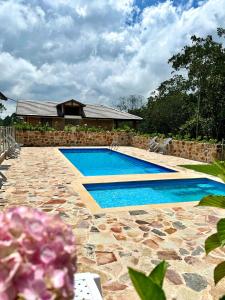 a swimming pool in front of a house at Magnífica Cabaña en Pony Parque Mesa de los Santos in Piedecuesta
