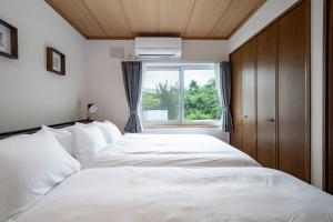 ein Schlafzimmer mit einem großen weißen Bett mit einem Fenster in der Unterkunft Asahikawa - House - Vacation STAY 20194 in Shin-asahigawa