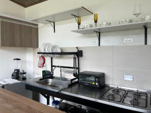 une cuisine avec un évier et une cuisinière four supérieur dans l'établissement Xie House, à Ubalá