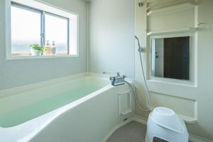 a white bathroom with a tub and a window at Aso Play - Harmony and Unity - Vacation STAY 42457v in Uchinomaki +39 photos