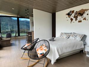 une chambre avec un lit et des chaises avec une carte au mur dans l'établissement Xie House, à Ubalá