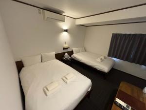 une chambre d'hôtel avec deux lits et une fenêtre dans l'établissement Hakodate City - Hotel - Vacation STAY 61124v, à Naka-hamachō