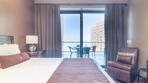 a hotel room with a bed and a chair and a window at 2BR 2BA condo @ Las Palomas Cabrillo 804 in Puerto Peñasco +29 photos