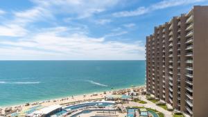 a view of the beach and the ocean from a building at 2BR 2BA condo @ Las Palomas Cabrillo 804 in Puerto Peñasco