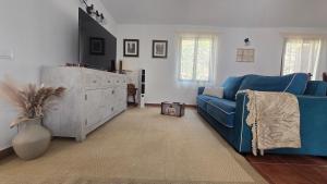 a living room with a blue couch and a dresser at The Haven of Happiness in Fátaga