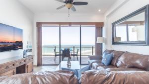 a living room with a couch and a view of the ocean at Las Palomas 2 BR 2 BA Diamante 707 in Puerto Peñasco