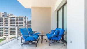 a patio with blue chairs and a table on a balcony at Las Palomas 2 BR 2 BA Diamante 707 in Puerto Peñasco