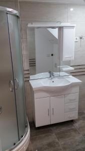 a white bathroom with a sink and a shower at Apartment Soric in Senj