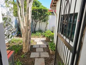 a walkway with a tree next to a house at The Little Haven in Midrand