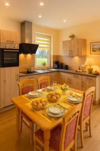 una cocina con una mesa de madera con platos y copas de vino en Seenlandliebe Wiesethblick bis 3 Personen, en Bechhofen