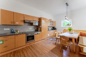 a kitchen with wooden cabinets and a table and a dining room at LummersDorf in Sankt Johann am Wimberg