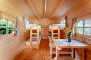 a tiny house with three bunk beds and a table at LummersDorf in Sankt Johann am Wimberg