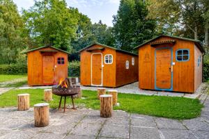 a group of orange houses with a fire in the middle at LummersDorf in Sankt Johann am Wimberg